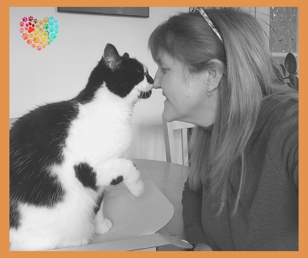 Lilly the cat with Angela touching noses. The pictures is black and white