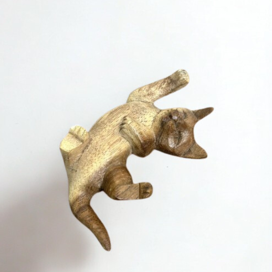 Hand-carved wooden cat ornament in a playful pose, made from natural sustainable wood with a smooth finish, displayed on a white background.
