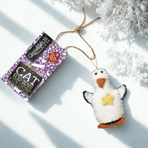 Wool felt penguin cat toy with catnip, displayed beside a Green & Wild’s tag and festive winter greenery.