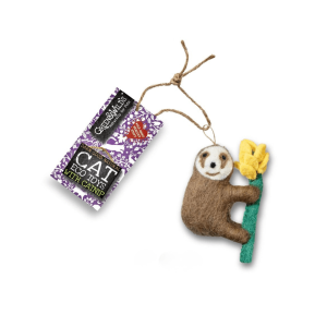 A wool-felt sloth cat toy holding a yellow flower, shown with a Green & Wilds eco toy tag on a plain white background.