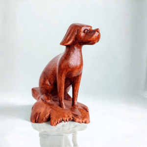 Hand-carved wooden Parasite Wood Dog ornament displayed on a reflective surface with a light background.