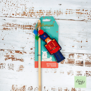 Festive Nutcracker Cat Teaser toy featuring red and blue felt Nutcracker with catnip and wooden wand handle from the Pet Brands Whimsical Collection.
