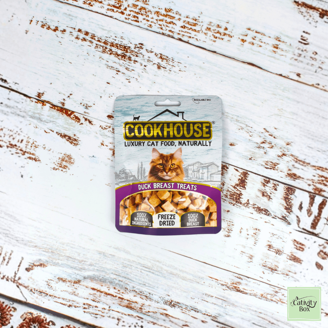 Cookhouse Freeze-Dried Duck Breast Cat Treats in resealable pouch displayed on white wooden background, 100% natural single-ingredient treats.